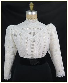 "100% Cotton. Color: White. Outstanding stripe cotton embroidered fabric blouse. Designed with matching white scalloped lace on front yoke, collar and cuffs. Full length lightly gathered sleeves, button back closure. First image shown without undergarment. Additional image shows blouse with white camisole worn underneath for modesty. Camisole undergarment not included. Machine washable. Circa 1890-1905. Made in U.S.A. Sizes: SM, MED, LG & XLG. Blouses ordered by bust measurement, inches: BUST SI Elegant Cotton Lace Patchwork Tops, Elegant Cotton Top With Lace Patchwork, Cotton Blouse With Lace Patchwork For Daywear, Fitted Cotton Lace Blouse With Lace Trim, Elegant Cotton Blouse With Lace Patchwork, Classic Blouse With Lace Cuffs For Work, Elegant Cotton Lace Blouse For Spring, Classic Cotton Blouse With Lace Trim, Victorian Cotton Fitted Blouse