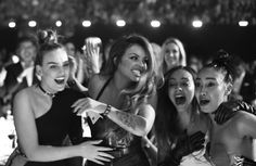 group of young women laughing and having fun at a nightclub or club with their hands in the air