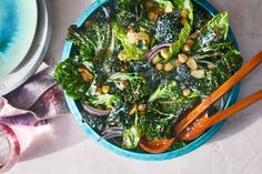 a blue bowl filled with salad and chopsticks on top of a white table