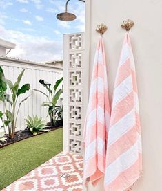 two pink and white towels hanging on the wall