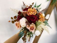 a bridal bouquet with red, orange and white flowers