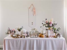 a table topped with lots of cakes and flowers