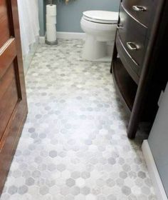 a white toilet sitting next to a wooden dresser