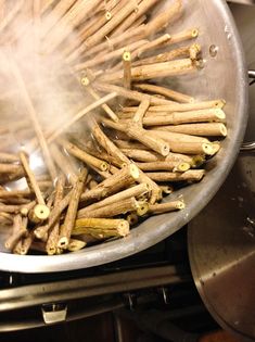 a pan filled with cinnamon sticks sitting on top of a stove