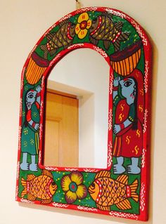 a colorful mirror hanging on the wall next to a door