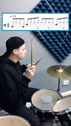 a man sitting in front of a drum set