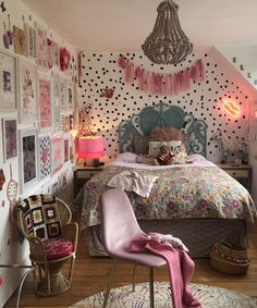 a bedroom decorated in pink and white with polka dot wallpaper