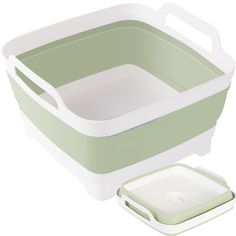 a green and white container with a lid next to an apple in front of it