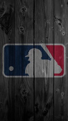 the major league logo is painted on a wooden fence with dark wood planks behind it