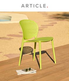 a green chair sitting on top of a wooden floor next to a swimming pool with the words article written above it