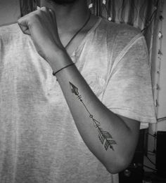 a man with a tattoo on his arm and an arrow in the middle of his arm