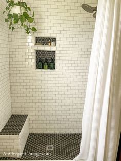 a white tiled bathroom with black and white floor tiles, shower curtain, and shelves