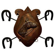 a metal horse head on a wooden plaque