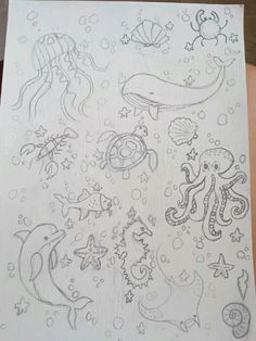 a drawing of sea animals and fish on white paper with black marker markers in the middle