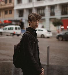 a young man is standing in the rain