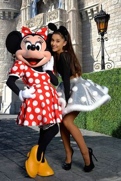 a woman hugging a minnie mouse in front of a castle with the words i love disneyland on it