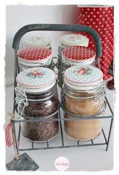 four glass jars are sitting on a wire rack