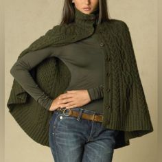 a woman is wearing a green sweater and jeans with her hands on her hips, posing for the camera