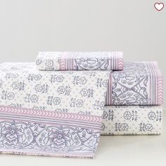 three sheets are stacked on top of each other in different patterns and colors, with hearts above them