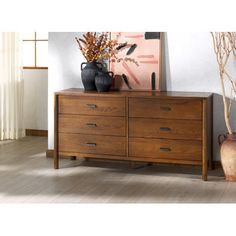 a wooden dresser with vases on top of it