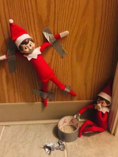 two elfs are on the floor next to an open door and one is holding a pair of scissors