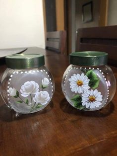 two glass vases with flowers painted on them