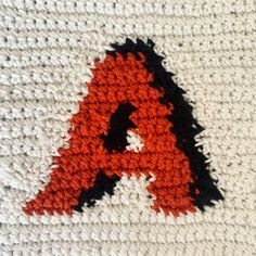 a crocheted blanket with the letter a on it