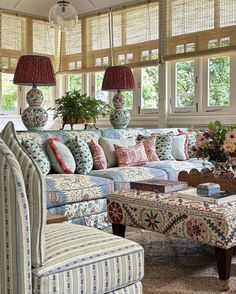 a living room filled with lots of furniture and decor on top of a carpeted floor