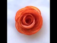 an orange flower sitting on top of a white table