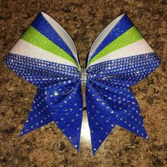 a blue, green and white cheer bow on a granite counter top with sparkles