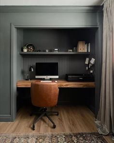 a desk with a computer on top of it in front of a bookshelf