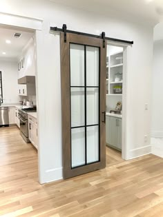 an open kitchen with sliding glass doors and wood flooring in the center of the room