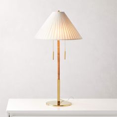 a lamp that is sitting on top of a white table next to a light bulb