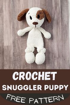 a crochet stuffed puppy sitting on top of a wooden floor next to a sign that says, crochet snuggler puppy free pattern