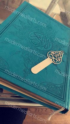 a blue book with an intricate design on the front and back cover is sitting on top of a stack of books