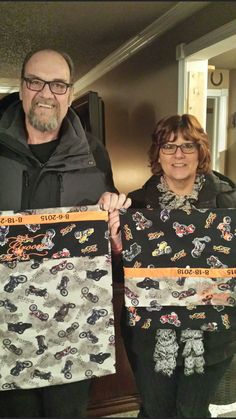 two people standing next to each other holding up large pieces of paper with bears on them