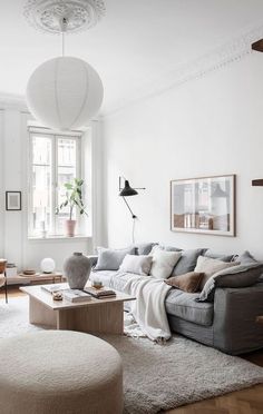 a living room filled with furniture and a white rug on the floor in front of a window