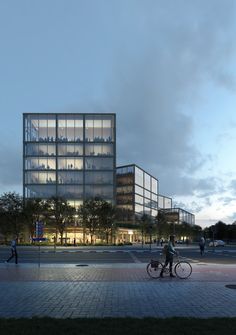 a man riding a bike next to a tall glass building with people walking around it