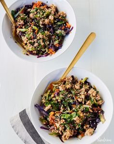 two white bowls filled with food on top of a table