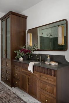 a bathroom with wooden cabinets and marble counter tops