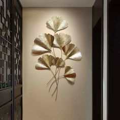 a metal wall sculpture with gold leaves on it