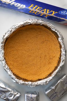 there is a pie in the pan next to some candy bar wrappers on the table