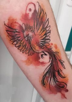 a watercolor style bird tattoo on the arm