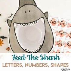 a paper shark with the words feed the shark and letters, shapes, and numbers