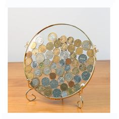 a glass plate filled with coins sitting on top of a wooden table