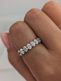 a woman's hand with a diamond ring on top of her finger, showing the five stones