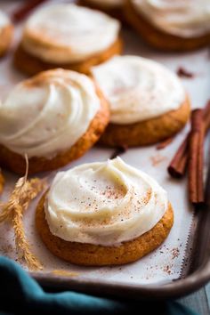 cookies with icing and cinnamon sticks on a baking sheet, ready to be eaten