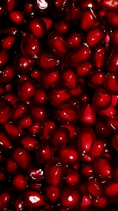 a close up view of some red candy beans with water droplets on them, as if they were floating in the air