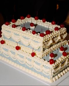 a cake with cherries on it sitting on a table