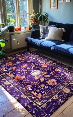 a living room with a blue couch and purple rug on the floor in front of a window